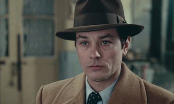 Movie still from “Mr. Klein” (1976), directed by Joseph Losey – A person wearing a suit and hat; Close Up shot, High angle