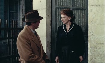 Movie still from “Mr. Klein” (1976), directed by Joseph Losey – A man and a woman standing next to each other; Medium shot, Over the shoulder angle