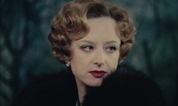 Movie still from “Mr. Klein” (1976), directed by Joseph Losey – An older woman wearing a black fur coat and red lipstick; Close Up shot, Low angle