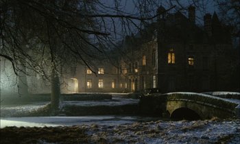 Movie still from “Mr. Klein” (1976), directed by Joseph Losey – A large building in the middle of a snowy field at night; Extreme Wide shot, High angle