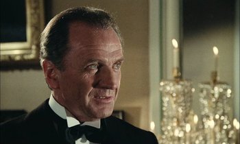 Movie still from “Mr. Klein” (1976), directed by Joseph Losey – An older man in a black suit and a white bow tie; Close Up shot, Over the shoulder angle