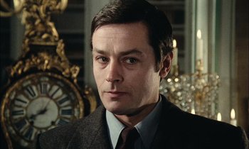 Movie still from “Mr. Klein” (1976), directed by Joseph Losey – A person wearing a suit and tie; Close Up shot, Low angle