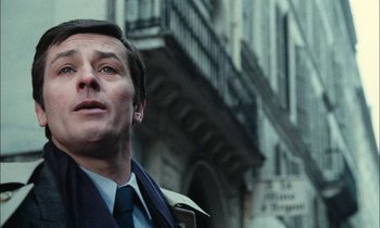 Movie still from “Mr. Klein” (1976), directed by Joseph Losey – A person wearing a suit and tie; Close Up shot, Low angle