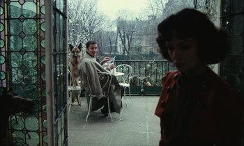 Movie still from “Mr. Klein” (1976), directed by Joseph Losey – A man sitting on a chair next to a dog on a porch; Wide shot, Over the shoulder angle