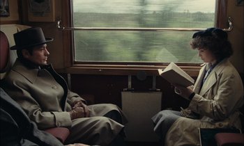 Movie still from “Mr. Klein” (1976), directed by Joseph Losey – Two people are sitting on a train looking out the window; Medium shot, Over the shoulder angle