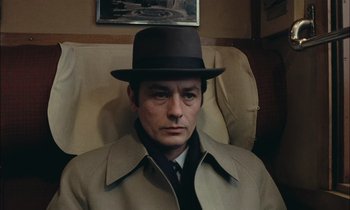 Movie still from “Mr. Klein” (1976), directed by Joseph Losey – A man wearing a hat sitting in a chair; Close Up shot, High angle