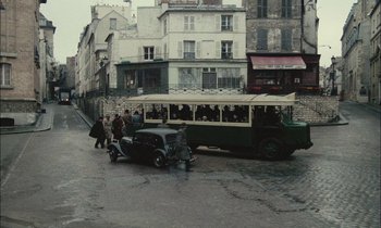 Movie still from “Mr. Klein” (1976), directed by Joseph Losey – An old car is parked on the side of the street; Extreme Wide shot, High angle