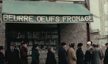 Movie still from “Mr. Klein” (1976), directed by Joseph Losey – A group of people standing in front of a building; Wide shot, High angle
