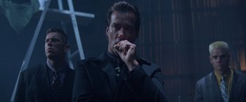 Movie still from “Mr. Nice Guy” (1997), directed by Sammo Kam-Bo Hung – A man in a black jacket is holding a piece of food in his hand; Close Up shot, Low angle