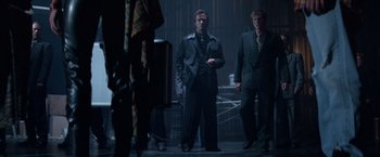 Movie still from “Mr. Nice Guy” (1997), directed by Sammo Kam-Bo Hung – A man in a suit and tie standing next to another man in a suit and tie; Medium shot, Low angle