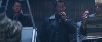 Movie still from “Mr. Nice Guy” (1997), directed by Sammo Kam-Bo Hung – A man smoking a cigarette while wearing a suit; Medium shot, Low angle