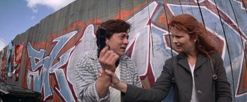 Movie still from “Mr. Nice Guy” (1997), directed by Sammo Kam-Bo Hung – A man holding another man's hand while he is chained to a wall; Medium shot, Low angle