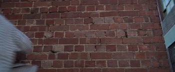Movie still from “Mr. Nice Guy” (1997), directed by Sammo Kam-Bo Hung – View of a brick wall; Wide shot, Low angle