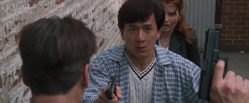 Movie still from “Mr. Nice Guy” (1997), directed by Sammo Kam-Bo Hung – A man holding a gun in front of another man and a woman; Close Up shot, Over the shoulder angle