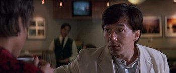 Movie still from “Mr. Nice Guy” (1997), directed by Sammo Kam-Bo Hung – A man in a white suit is looking at the camera; Close Up shot, Over the shoulder angle