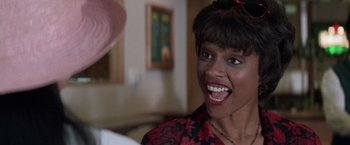 Movie still from “Mr. Nice Guy” (1997), directed by Sammo Kam-Bo Hung – A person smiling with a hat in the background; Close Up shot, Over the shoulder angle