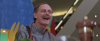 Movie still from “Mr. Nice Guy” (1997), directed by Sammo Kam-Bo Hung – An older man with a mustache is smiling for the camera; Close Up shot, Low angle