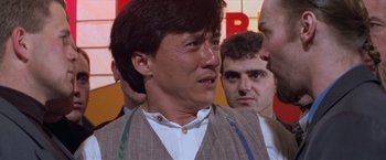 Movie still from “Mr. Nice Guy” (1997), directed by Sammo Kam-Bo Hung – A person wearing a suit and a tie; Close Up shot, Over the shoulder angle