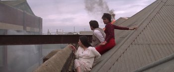 Movie still from “Mr. Nice Guy” (1997), directed by Sammo Kam-Bo Hung – A group of people sitting on top of a building; Wide shot, High angle