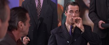 Movie still from “Mr. Nice Guy” (1997), directed by Sammo Kam-Bo Hung – A man smoking a cigar in front of another man; Medium shot, Low angle