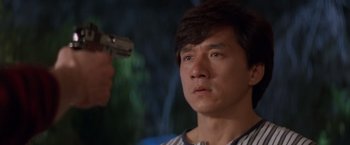 Movie still from “Mr. Nice Guy” (1997), directed by Sammo Kam-Bo Hung – A person holding a gun; Close Up shot, Over the shoulder angle