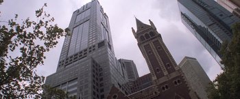 Movie still from “Mr. Nice Guy” (1997), directed by Sammo Kam-Bo Hung – A very tall building with a very tall clock tower in front of it; Extreme Wide shot, Low angle