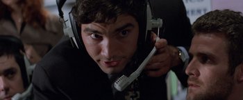 Movie still from “Mr. Nice Guy” (1997), directed by Sammo Kam-Bo Hung – A man with a headset is looking at the camera; Close Up shot, Overhead angle