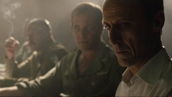 Movie still from “Munich” (2005), directed by Steven Spielberg – A group of men sitting next to each other in a room; Close Up shot, Over the shoulder angle