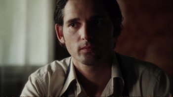 Movie still from “Munich” (2005), directed by Steven Spielberg – A person wearing a white shirt; Close Up shot, Over the shoulder angle