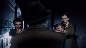 Movie still from “Munich” (2005), directed by Steven Spielberg – A group of men holding guns in front of a mirror; Medium shot, Over the shoulder angle