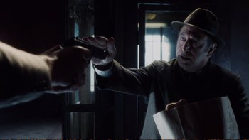 Movie still from “Munich” (2005), directed by Steven Spielberg – An old man holding a knife in his hand; Close Up shot, Over the shoulder angle
