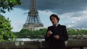 Movie still from “Munich” (2005), directed by Steven Spielberg – A man standing in front of the eiffel tower; Medium shot, Low angle
