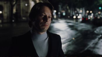Movie still from “Munich” (2005), directed by Steven Spielberg – A man in a suit standing in the street; Close Up shot, Low angle