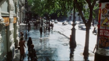 Movie still from “Munich” (2005), directed by Steven Spielberg – People are walking down the street on a rainy day; Extreme Wide shot, High angle