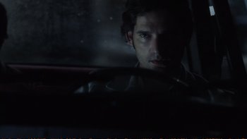 Movie still from “Munich” (2005), directed by Steven Spielberg – A man sitting in a car in the dark; Close Up shot, Over the shoulder angle