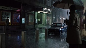 Movie still from “Munich” (2005), directed by Steven Spielberg – A car parked on the side of the street in the rain; Wide shot, Low angle