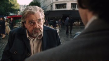 Movie still from “Munich” (2005), directed by Steven Spielberg – An older man is looking at a younger man in the street; Close Up shot, Over the shoulder angle