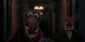 Movie still from “Muppets Haunted Mansion” (2021), directed by Kirk R. Thatcher – A puppet wearing a suit and tie; Close Up shot, Over the shoulder angle
