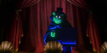 Movie still from “Muppets Haunted Mansion” (2021), directed by Kirk R. Thatcher – A person in a green suit and a top hat; Wide shot, Low angle
