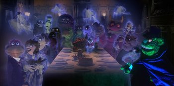 Movie still from “Muppets Haunted Mansion” (2021), directed by Kirk R. Thatcher – A group of monsters standing around a table; Wide shot, High angle