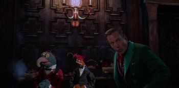 Movie still from “Muppets Haunted Mansion” (2021), directed by Kirk R. Thatcher – A man in a green jacket standing in front of a group of stuffed animals; Medium shot, Over the shoulder angle