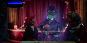 Movie still from “Muppets Haunted Mansion” (2021), directed by Kirk R. Thatcher – A puppet of kermit the frog and the muppets character gonzo; Medium shot, Over the shoulder angle