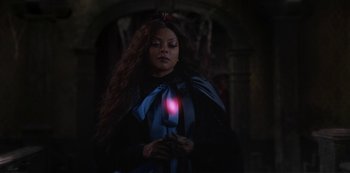 Movie still from “Muppets Haunted Mansion” (2021), directed by Kirk R. Thatcher – A woman with long hair holding a light in her hand; Medium shot, Over the shoulder angle