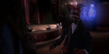 Movie still from “Muppets Haunted Mansion” (2021), directed by Kirk R. Thatcher – A man in a suit with a mask on his face; Medium shot, High angle