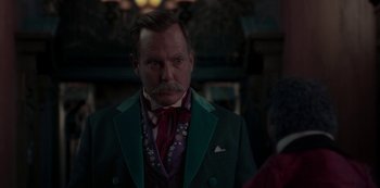 Movie still from “Muppets Haunted Mansion” (2021), directed by Kirk R. Thatcher – A man in a green suit and a red tie; Close Up shot, Over the shoulder angle