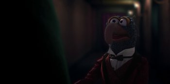 Movie still from “Muppets Haunted Mansion” (2021), directed by Kirk R. Thatcher – A muppet wearing a suit and a tie; Close Up shot, Over the shoulder angle