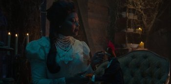 Movie still from “Muppets Haunted Mansion” (2021), directed by Kirk R. Thatcher – A woman in a white dress holding a red flower; Medium shot, Over the shoulder angle