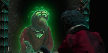 Movie still from “Muppets Haunted Mansion” (2021), directed by Kirk R. Thatcher – A green light shines on a person in a costume; Medium shot, Over the shoulder angle