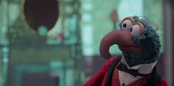 Movie still from “Muppets Haunted Mansion” (2021), directed by Kirk R. Thatcher – A stuffed animal wearing a suit and tie; Close Up shot, Over the shoulder angle