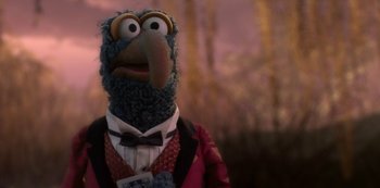 Movie still from “Muppets Haunted Mansion” (2021), directed by Kirk R. Thatcher – A stuffed animal wearing a suit and tie; Close Up shot, Over the shoulder angle